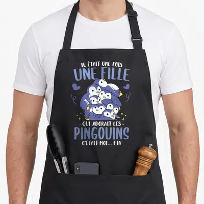 Tablier de cuisine noir avec une illustration de pingouins et le texte Il était une fois une fille qui adorait les pingouins.