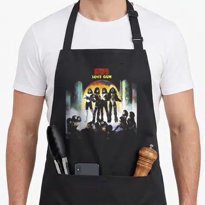 Tablier de cuisine noir avec illustration Love Gun KISS 1977 et quatre personnages en costumes de scène.