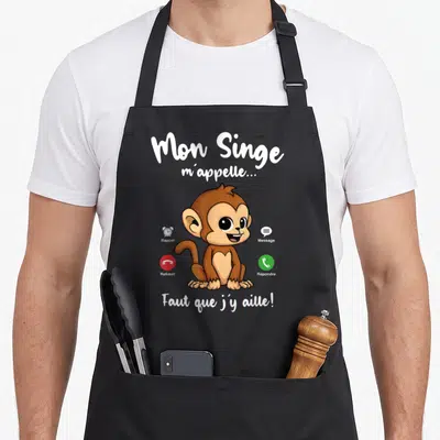 Tablier de cuisine noir avec un singe marron entouré de boutons de téléphone et du texte Mon Singe m'appelle Faut que j'y aille.