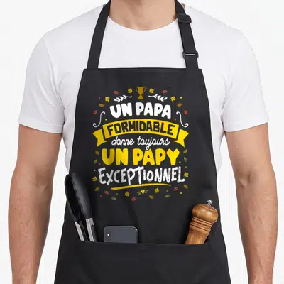 Tablier de cuisine noir avec l'inscription Un papa formidable donne toujours un papy exceptionnel entouré de feuilles et d'un trophée doré.