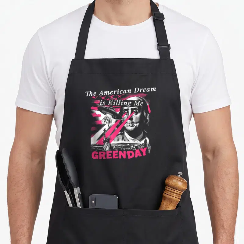 Tablier de cuisine noir avec illustration rose et blanche du dollar et d'un vaisseau spatial.