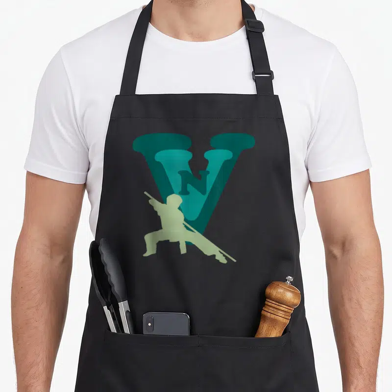 Tablier de cuisine noir avec le logo VVN Viet Vo Dao et une silhouette de pratiquant au bâton en vert clair.