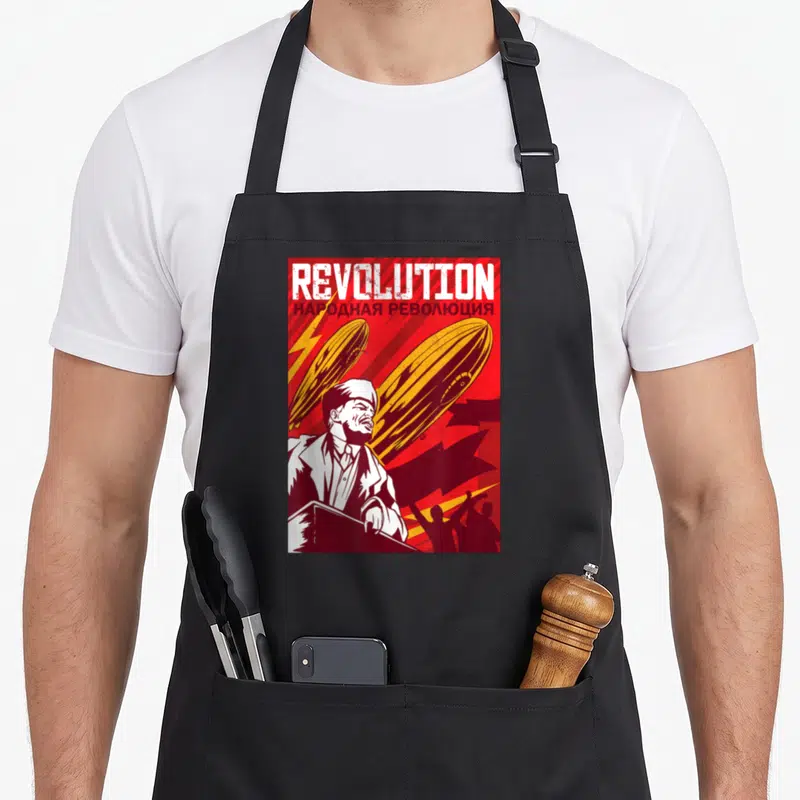 Tablier de cuisine noir avec illustration rouge et jaune style propagande représentant un homme et des aéronefs.