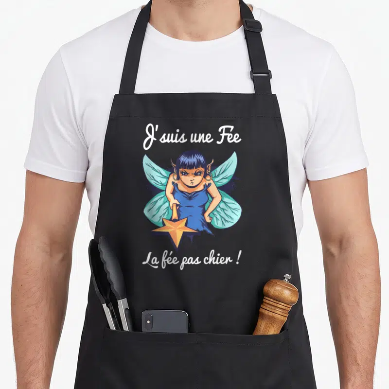 Tablier de cuisine noir avec illustration d'une fée aux ailes bleues tenant une baguette étoilée et le texte J'suis une Fée La fée pas chier.