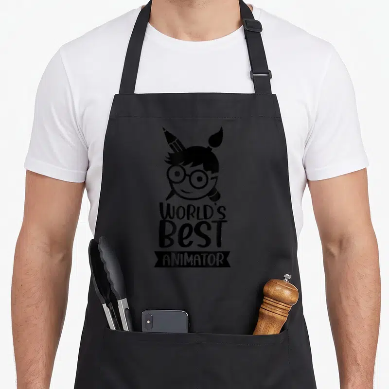 Tablier de cuisine noir avec illustration d'un animateur aux lunettes et outils artistiques sur le devant.