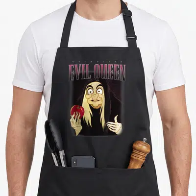 Tablier de cuisine noir avec illustration de la Reine méchante Grimhilde tenant une pomme rouge.