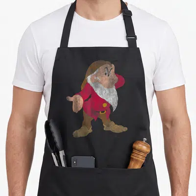 Tablier de cuisine noir avec illustration colorée du nain Grumpy en tenue rouge et marron.