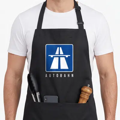 Tablier de cuisine noir avec un panneau Autobahn bleu et blanc illustrant une route libre.