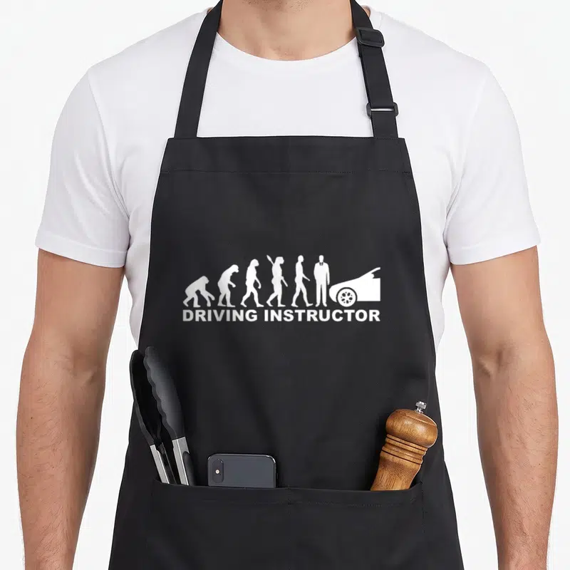 Tablier de cuisine noir avec illustration blanche de l'évolution humaine et texte driving instructor