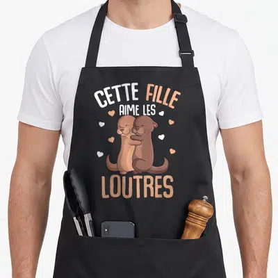 Tablier de cuisine noir avec deux loutres marron s'embrassant et le texte Cette Fille Aime Les Loutres Enfant.
