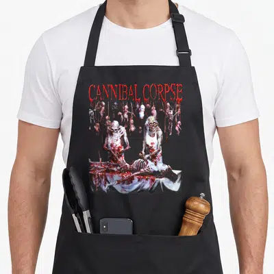 Tablier de cuisine noir avec illustration sanguinolente de squelettes et texte rouge cannibal corpse en haut.
