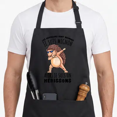 Tablier de cuisine noir avec un hérisson marron en train de faire le dab et des lunettes de soleil bleues.