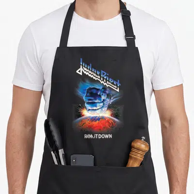Tablier de cuisine noir avec le poing bleu et le texte Judas Priest Ram It Down imprimé au centre.