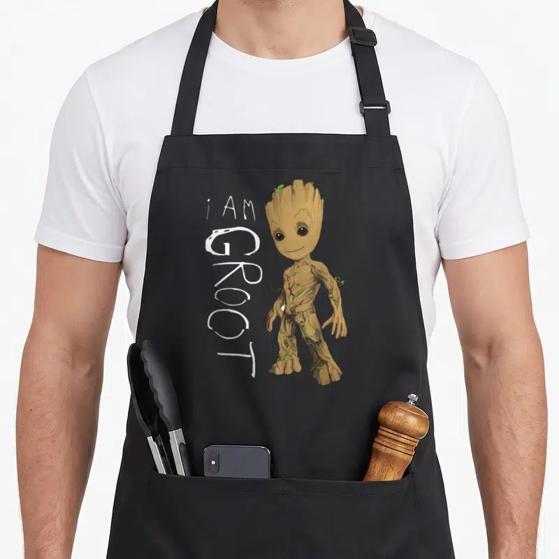 Tablier de cuisine noir avec une illustration de Groot enfant et l'inscription manuscrite I AM GROOT en blanc.
