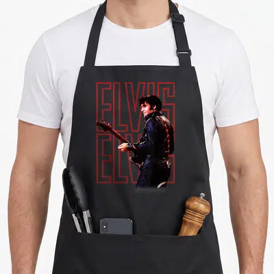 Tablier de cuisine noir avec Elvis Presley en veste noire et texte ELVIS formingé de points rouges.