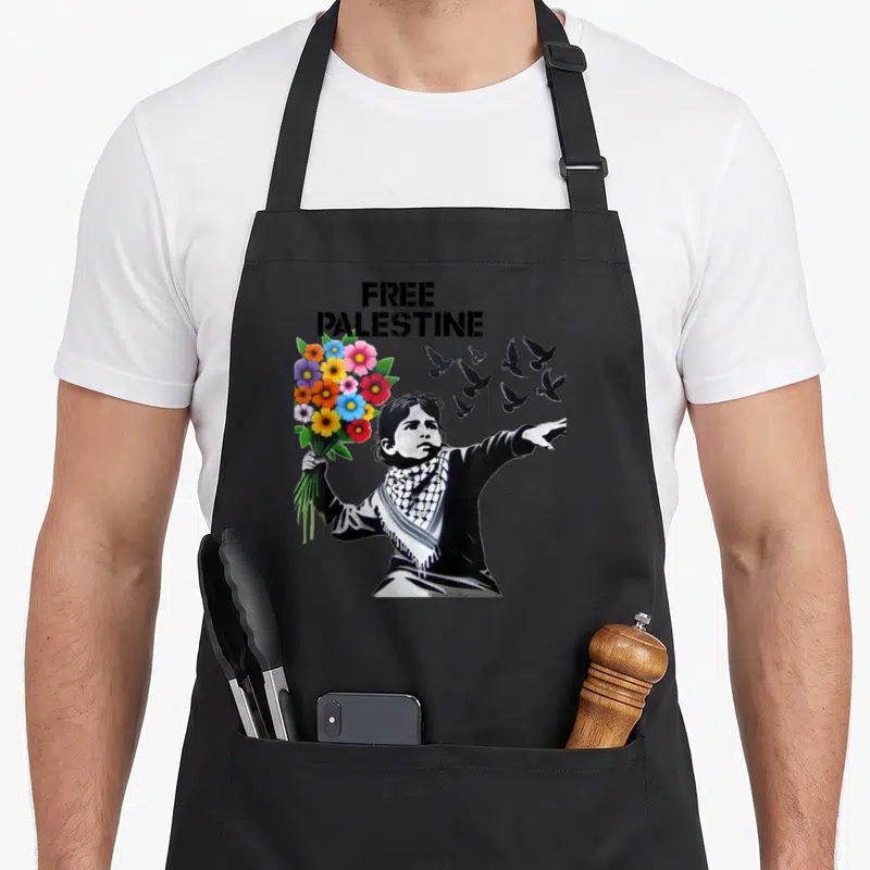 Tablier de cuisine noir avec Free Palestine, enfant aux fleurs et pigeons en silhouette noire.