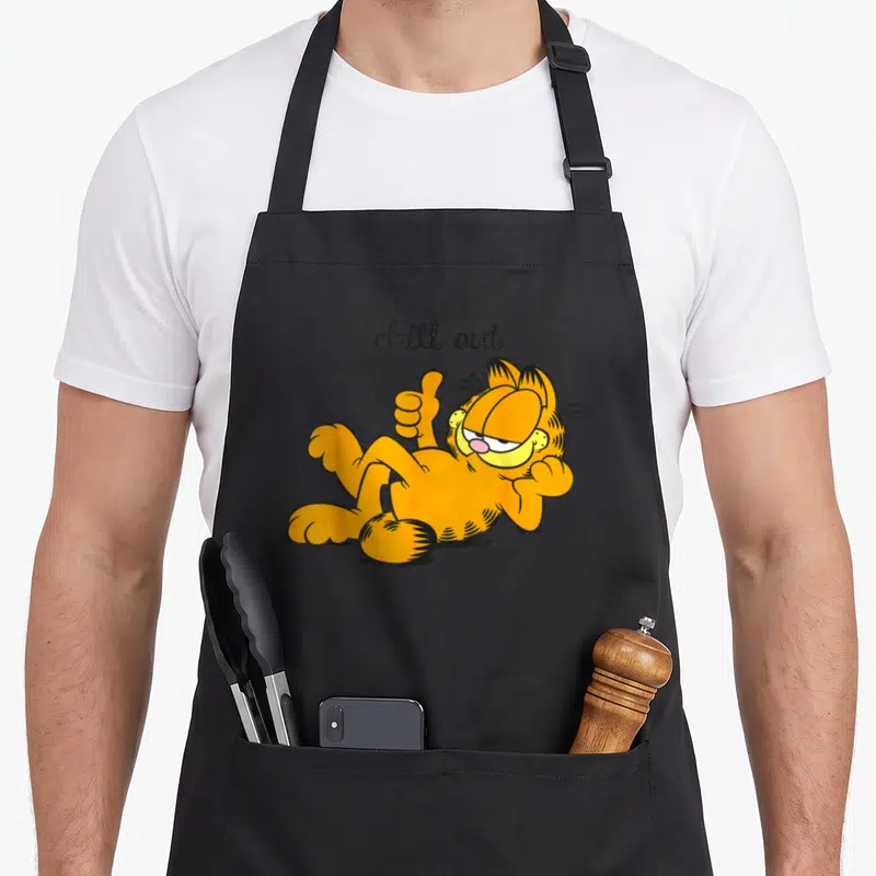 Tablier de cuisine noir avec Garfield orange allongé et l'inscription chill out en lettres noires cursives.