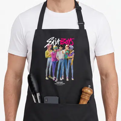 Tablier de cuisine noir avec l'illustration colorée du groupe Saja Boys et le titre Kpop Demon Hunters en bas.