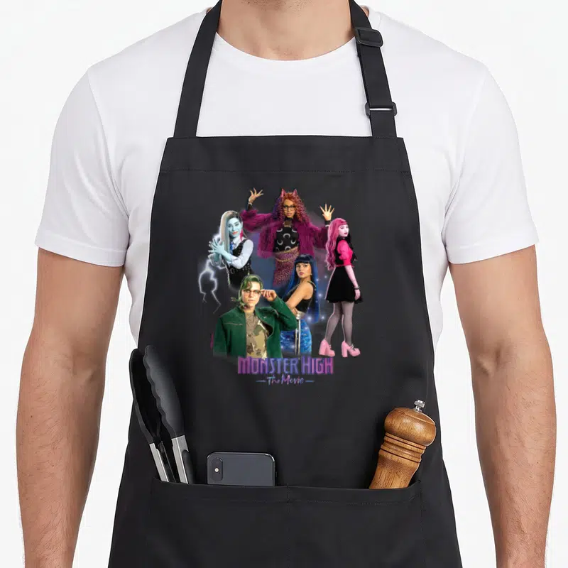 Tablier de cuisine noir avec cinq personnages de film d'animation et un logo violet en bas de l'impression centrale.