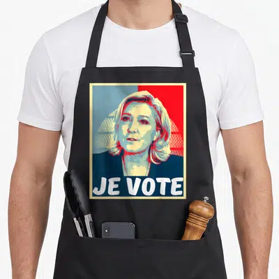 Tablier de cuisine noir avec portrait stylisé et texte Je Vote en grandes lettres blanches sur fond rouge et bleu.