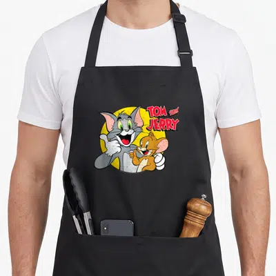Tablier de cuisine noir avec Tom et Jerry souriants et les pouces levés devant un cercle jaune.