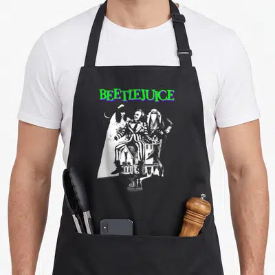 Tablier de cuisine noir avec illustration Beetlejuice en noir et blanc et titre vert violet