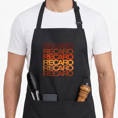 Tablier de cuisine noir avec le mot RECARO répété six fois en lettres majuscules aux couleurs dégradées du bordeaux au jaune orangé.