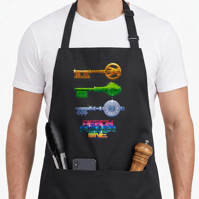 Tablier de cuisine noir avec trois clés stylisées dorée verte et argentée sous un logoReady Player One multicolore