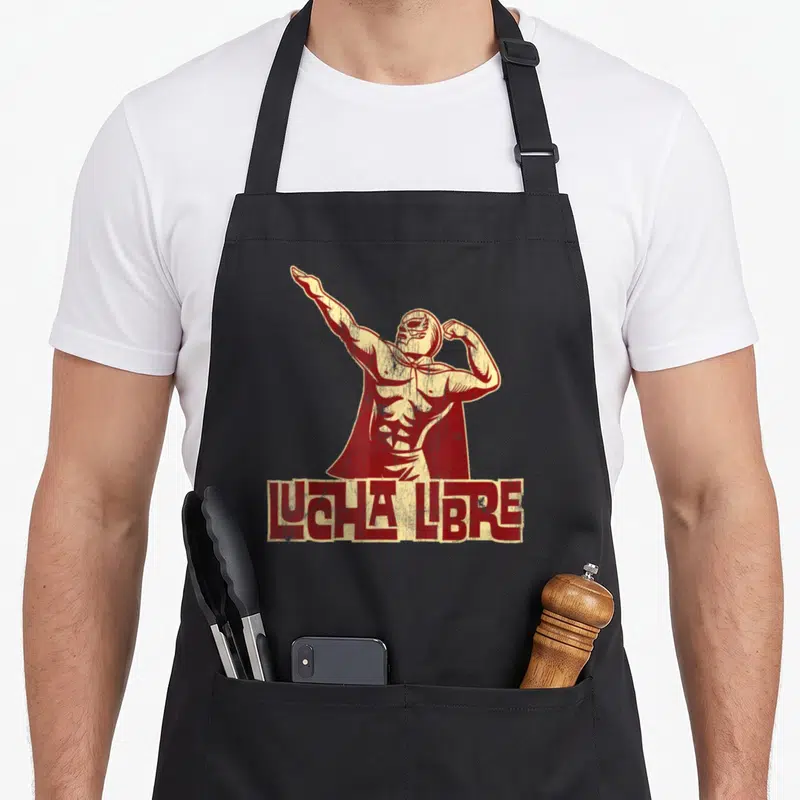 Tablier de cuisine noir avec illustration vintage d'un luchador masqué et texte Lucha Libre en bas.