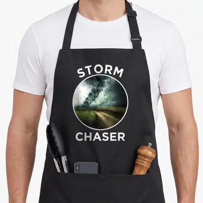 Tablier de cuisine noir avec une tornade photographiée dans un cercle blanc et les mots STORM CHASER en lettres capitales au-dessus et en dessous.