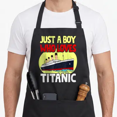 Tablier de cuisine noir avec illustration colorée du paquebot Titanic et typographie anglaise en jaune, rouge et blanc.