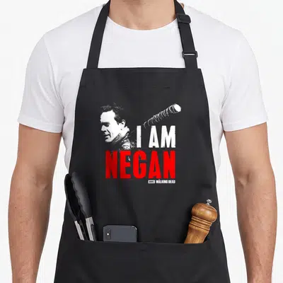 Tablier de cuisine noir avec illustration blanche de Negan, texte I AM NEGAN en rouge et une batte enveloppée de fil de fer.