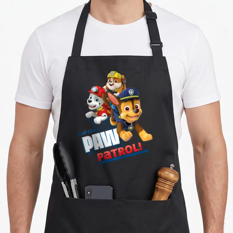 Tablier de cuisine noir avec Chase, Marshall et Rubble en action sous le texte Call the PAW PATROL.