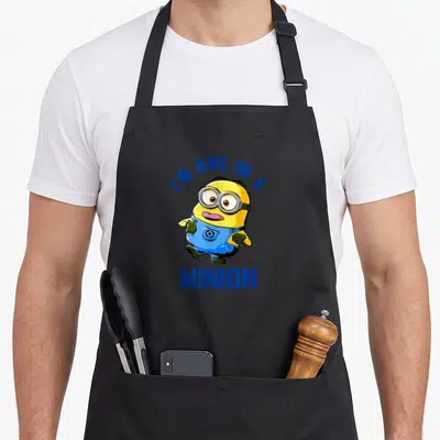Tablier de cuisine noir avec un Minion aux lunettes et la bouche ouverte, entouré du texte bleu I'm one in a Minion.