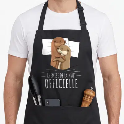 Tablier de cuisine noir avec deux loutres s'enlaçant et le texte « chemise de la nuit » imprimés en blanc.