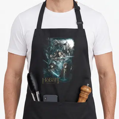 Tablier de cuisine noir avec une illustration sombre de Bilbon, Gandalf et des nains brandissant des lames luminescentes.