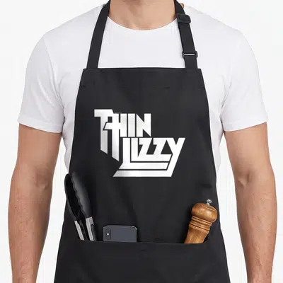 Tablier de cuisine noir avec le logo blanc empilé Thin Lizzy en typographie géométrique anguleuse.