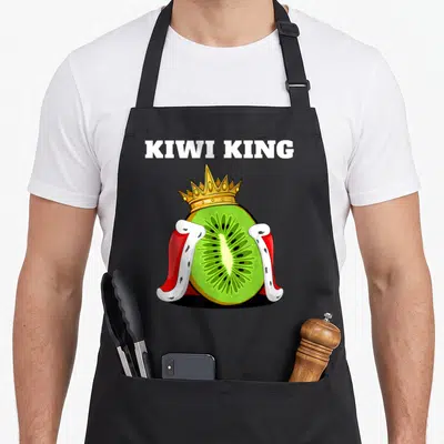 Tablier de cuisine noir avec un kiwi royal portant une couronne dorée et une cape rouge.