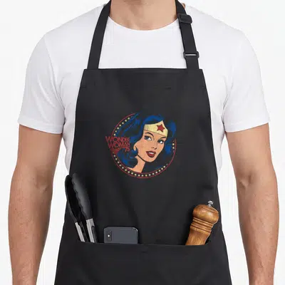 Tablier de cuisine noir avec portrait vintage de Wonder Woman 75 encadré d'étoiles dorées et texte rouge.