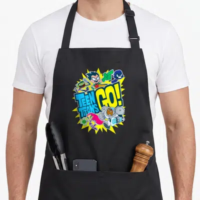 Tablier de cuisine noir avec illustration colorée des Teen Titans Go. Team et un effet d'explosion jaune en arrière-plan.