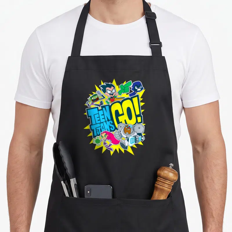 Tablier de cuisine noir avec illustration colorée des Teen Titans Go. Team et un effet d'explosion jaune en arrière-plan.