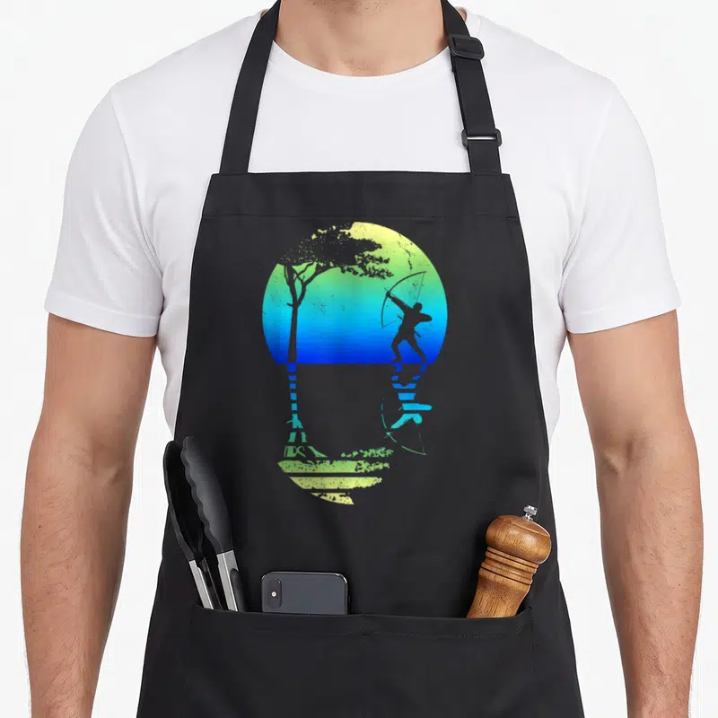 Tablier de cuisine noir avec silhouette d'archer tirant une flèche devant un arbre sur fond dégradé bleu et vert.
