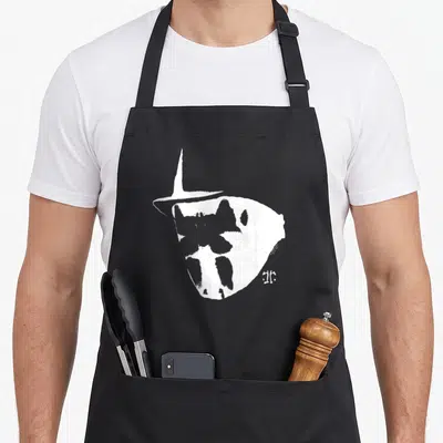 Tablier de cuisine noir avec illustration blanche du masque de Rorschach et signature artistique à côté.