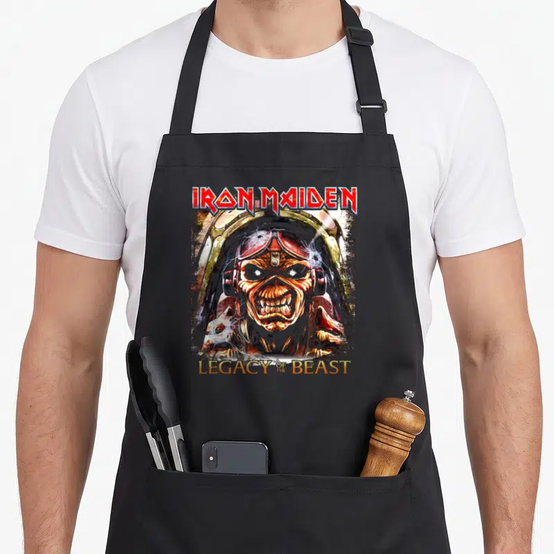Tablier de cuisine noir avec illustration d'Eddie en pilote et texte Iron Maiden Legacy of the Beast.