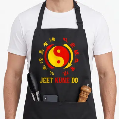 Tablier de cuisine noir avec un logo Yin Yang rouge et jaune entouré de caractères chinois et du texte Jeet Kune Do en bas.