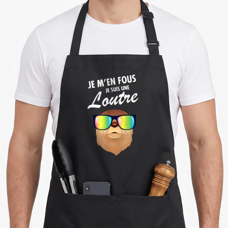 Tablier de cuisine noir avec illustration d'une loutre portant des lunettes de soleil colorées et du texte blanc en haut.