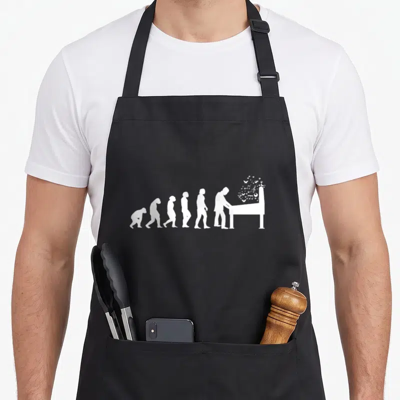 Tablier de cuisine noir avec silhouette évolutive humaine se transformant en pianiste au piano blanc.