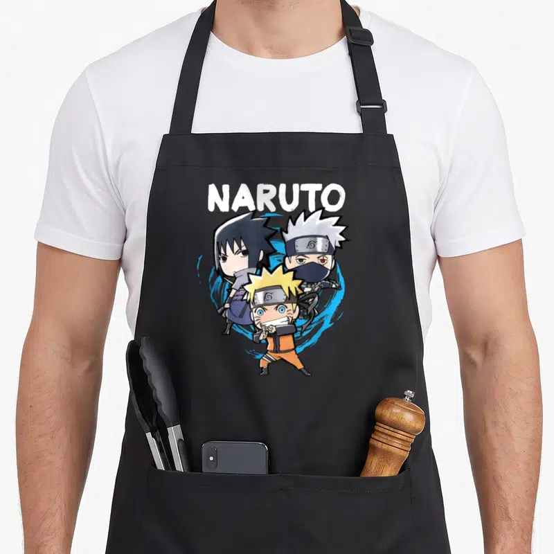 Tablier de cuisine noir avec illustration colorée de trois personnages chibi et le mot Naruto en lettres blanches au-dessus.