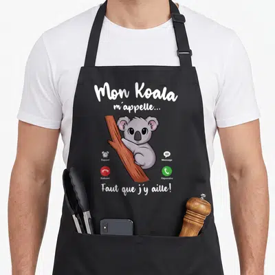 Tablier de cuisine noir avec illustration d'un koala gris accroché à une branche et texte blanc humoristique.