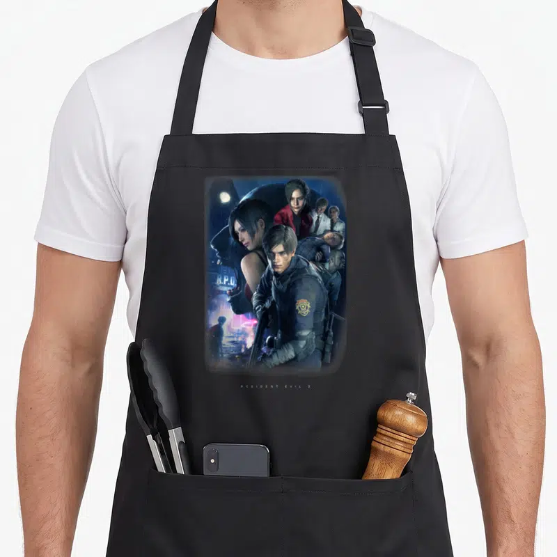 Tablier de cuisine noir avec illustration Resident Evil 2 montrant Leon, Claire et Ada sous la pluie devant le RPD.